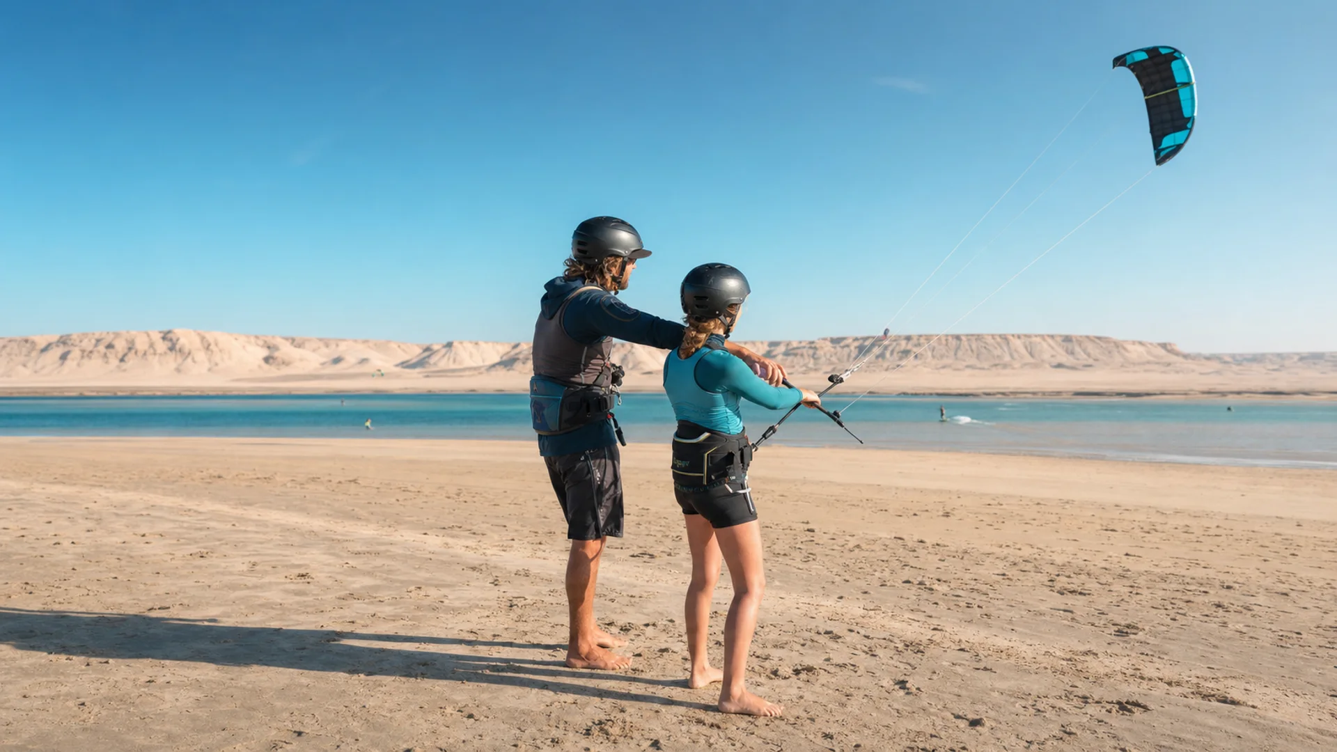 Débutant apprenant à piloter une aile de kitesurf avec un moniteur à Dakhla